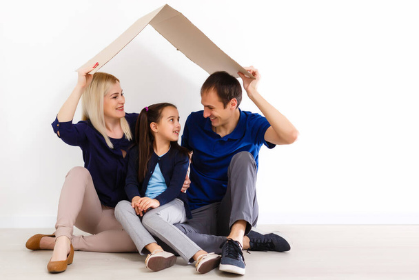 Konzept für eine junge Familie. Mutter, Vater und Kinder im neuen Zuhause - Foto, Bild