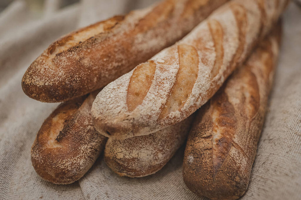 Buckwheat baguettes in baker's hands. Gluten free. Soft focus - Photo, Image