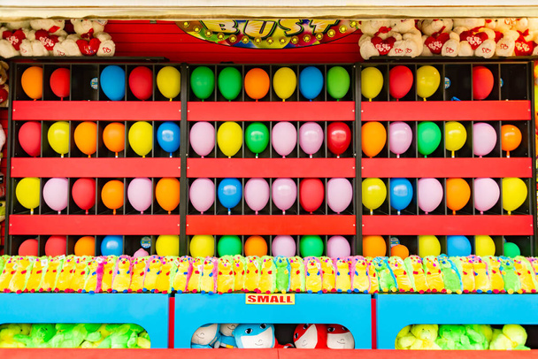 ballonnen en prijzen op een dart gooien spel stand op een carnaval, kermis of pretpark in Amerika - Foto, afbeelding