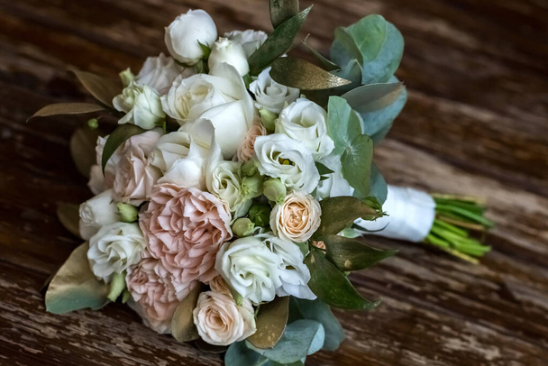 Hermoso bouguet de boda hecho de peonías blancas y rosadas sobre fondo de madera. decoración de la boda. El ramo de bodas de la novia. Decoración de flores frescas
 - Foto, imagen