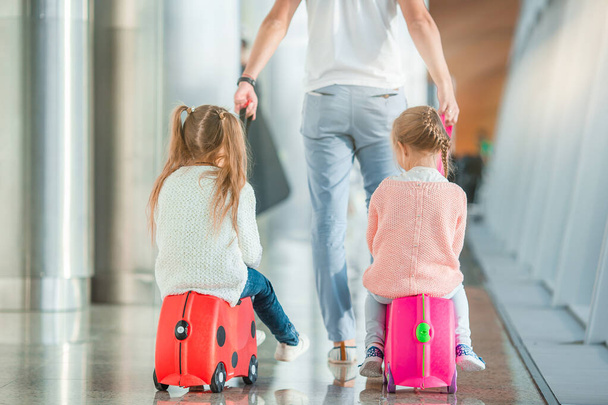 Familia feliz con dos niños en el aeropuerto se divierten esperando el embarque
 - Foto, Imagen
