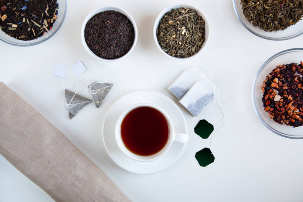 Válogatás száraz tea és teafilter kerek tálak fehér alapon. Felülnézet. - Fotó, kép