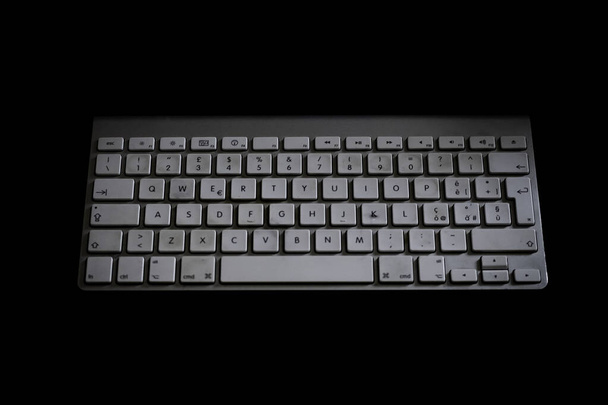 estação pc com teclado branco em um fundo preto
 - Foto, Imagem