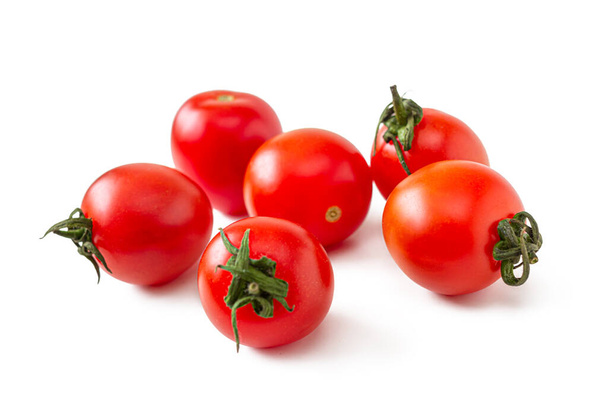 Kırmızı derili küçük vişneli domatesler ve beyaz arka planda izole edilmiş kuru yeşil kesikler. - Fotoğraf, Görsel
