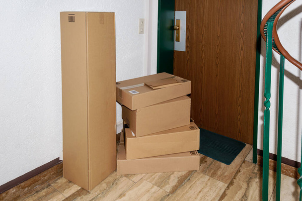 Montón de paquetes entregados frente a una puerta. Concepto de entrega de mercancías en tiempo de bloqueo o cuarentena
 - Foto, Imagen