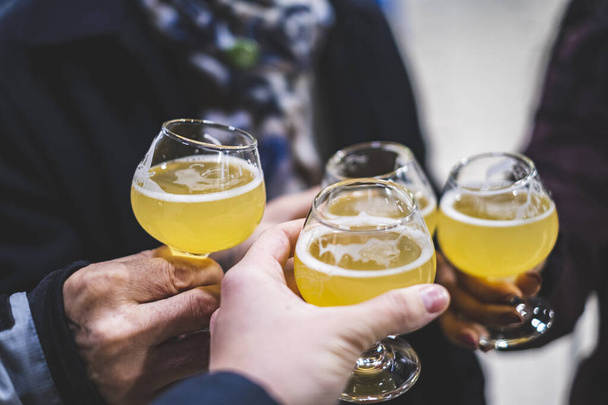Pessoas brindam (saúde) com cerveja em um bar
 - Foto, Imagem