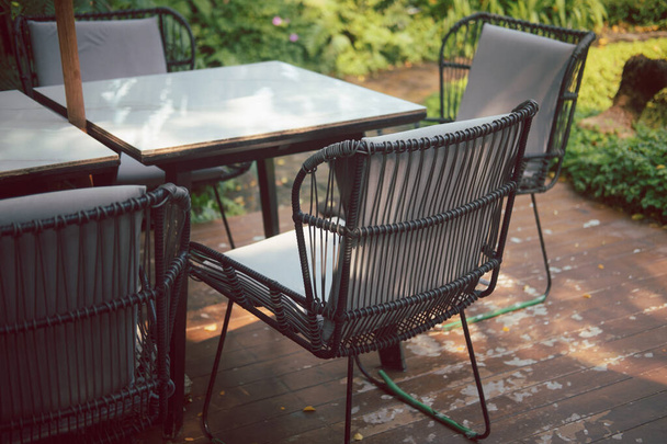 Металеве крісло і стіл у відкритому ресторані, їдальні або кафе
 - Фото, зображення