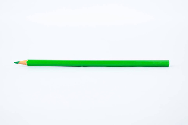 Un crayon vert unique en bois pointu placé sur un fond blanc isolé
 - Photo, image