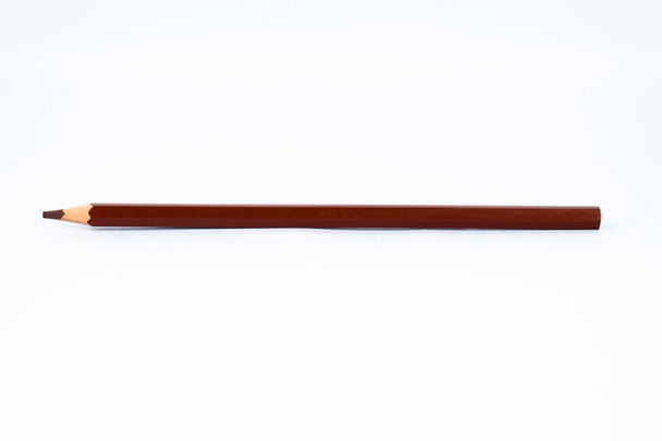 Um lápis de madeira bem afiado de cor marrom lápis isolado em um fundo branco claro
 - Foto, Imagem