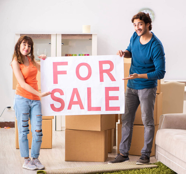 Joven familia ofreciendo casa para la venta y mudanza
 - Foto, Imagen