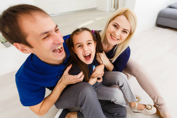 Feliz por ser uma família. Família feliz sorrindo enquanto sentado dentro de casa - Foto, Imagem