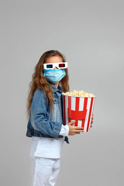 pieni lapsi tyttö naamio tilalla popcorn ämpäri
 - Valokuva, kuva