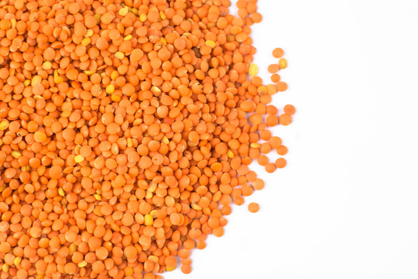 Sementes de lentilha de cor laranja empilhadas juntas em um montão antes de um fundo branco isolado
 - Foto, Imagem