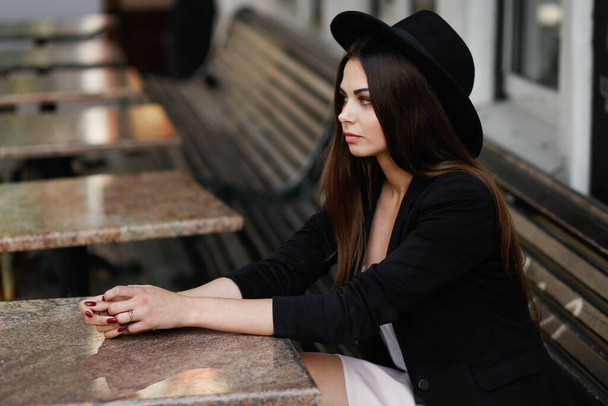 A woman sitting on a wooden bench - Zdjęcie, obraz