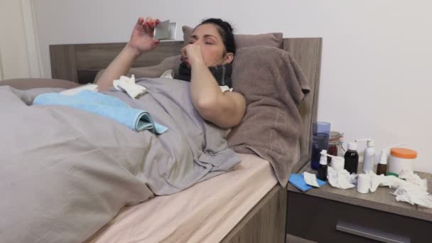 Άρρωστη γυναίκα στο κρεβάτι κρατώντας καθρέφτη και ελέγχοντας τη γλώσσα της - Πλάνα, βίντεο