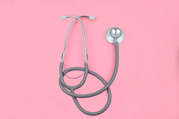 Normalny obraz pojedynczego normalnego stetoskopu wyizolowanego na wierzchu różowego koloru pustego tła papieru - Zdjęcie, obraz