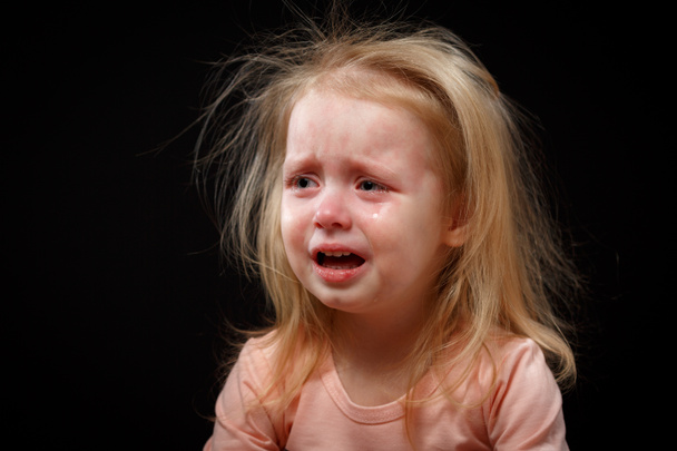 Emocjonalne dziecko dziewczynka płacze lub krzyczy z otwartymi ustami, ciemne tło. - Zdjęcie, obraz