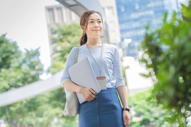 Asian (Japanese) female office worker working outdoors with a laptop - Foto, Imagem