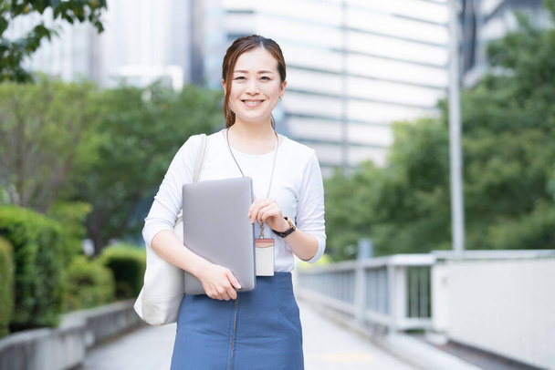 Aziatisch (Japans) vrouw kantoormedewerker werken buiten met een laptop - Foto, afbeelding