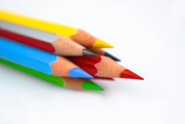 Siete lápices de colores diferentes dispuestos juntos en un círculo mientras que el lápiz rojo mirando hacia arriba
 - Foto, Imagen