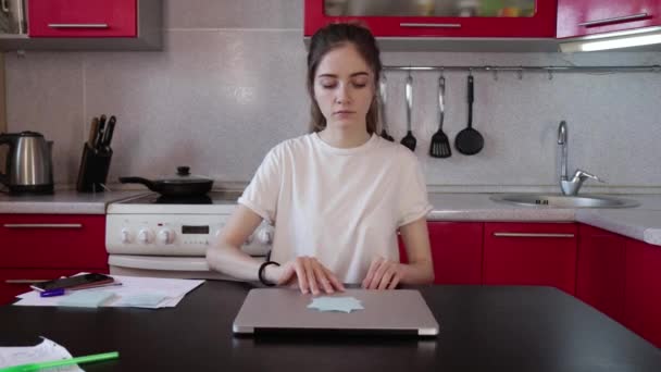 young girl open laptop and working in the kitchen at home - Séquence, vidéo