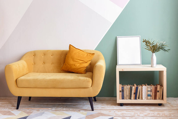 Pěkný obývací pokoj s pohovkou, koberec, zelená rostlina na knihovně - Fotografie, Obrázek