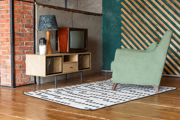 Quarto vintage com tapete, poltrona à moda antiga, tv retro, suporte de tv, vaso e lâmpada standart. Interior retro
 - Foto, Imagem