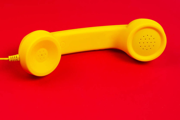 赤い背景に黄色の携帯電話。スペースのコピー. - 写真・画像