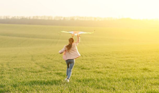 Cute girl flying bright kite - Foto, afbeelding
