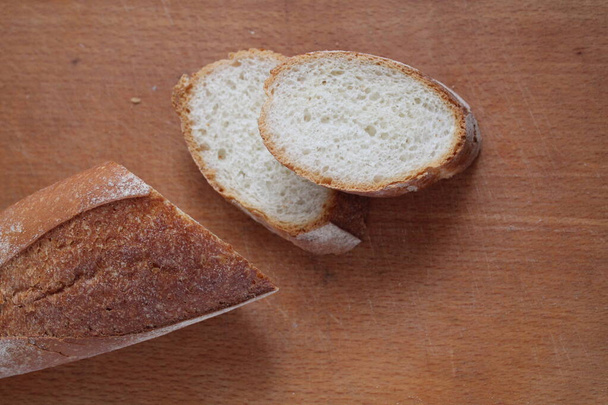 dos trozos de bagueta y bagueta de pan se encuentran en un tablero de corte de madera con espacio para insertar texto. - Foto, Imagen