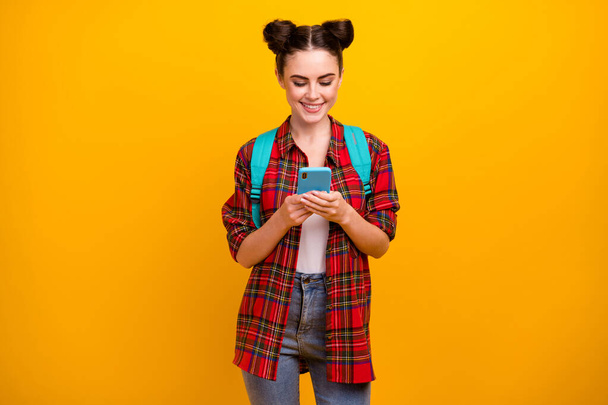 Photo of beautiful pretty student lady hold telephone freelance work and study read job email go lesson lecture wear blue bag casual checkered shirt jeans isolated yellow color background - Photo, image