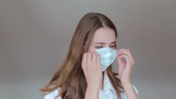 A girl in a medical mask prays with her hands folded in front of her. Demonstration of medical equipment. The concept of quarantine, self-isolation, protection from coronavirus, virus, fear of disease, treatment, medicine, religion - Video
