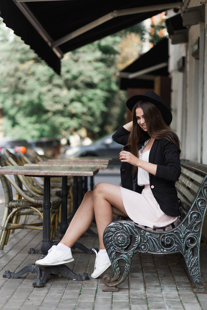 A woman sitting on a bench talking on a cell phone - Foto, afbeelding