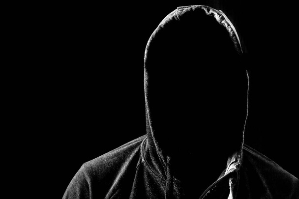 Mann ohne Gesicht im Kapuzenpullover. Dunkler, schwarzer Hintergrund - Foto, Bild