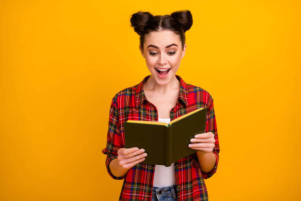 Photo of pretty student lady two cute buns open mouth hold book read interesting adventure story favorite novel wear casual white red plaid shirt isolated yellow color background - Photo, image