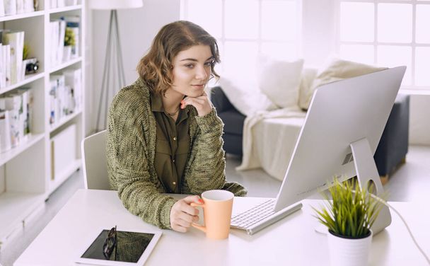 Jeune femme travaillant avec tablette graphique au bureau
 - Photo, image