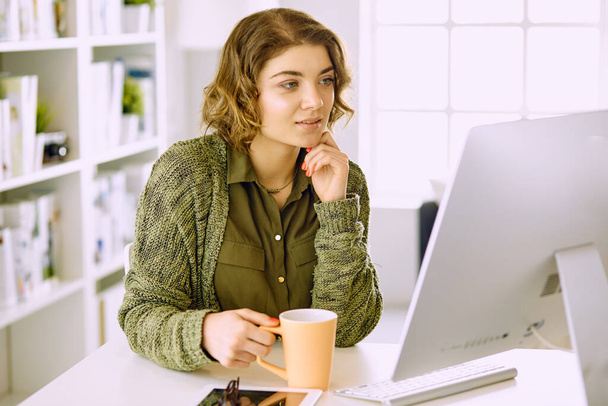 Молода жінка працює з графічним планшетом в офісі
 - Фото, зображення