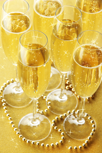 Glasses with champagne on shiny background - 写真・画像