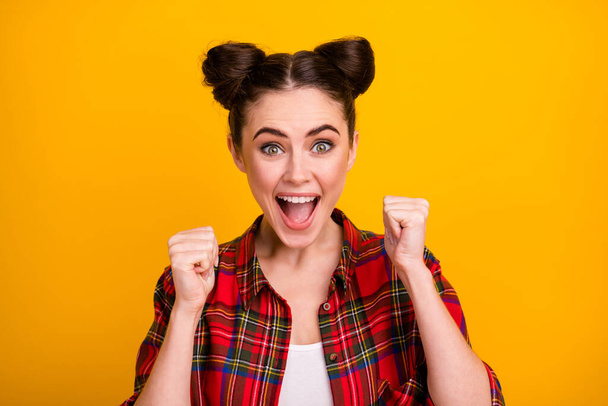 Photo of pretty crazy lady two cute buns yelling watch sports game match raise fists cheerleader support favorite team wear casual plaid shirt isolated yellow color background - Fotó, kép