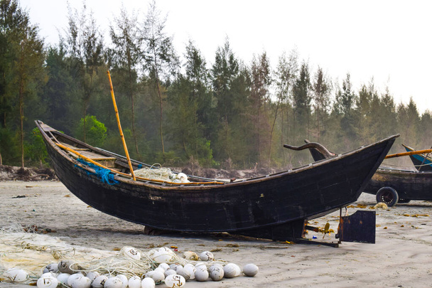 Um barco estacionado na margem de um oceano na praia do mar sem pessoas reais perto dele
 - Foto, Imagem