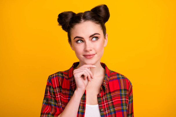 Closeup photo of attractive student lady two cute buns look side empty space intelligent dreamer arm on chin wear casual checkered shirt isolated bright yellow color background - Foto, immagini