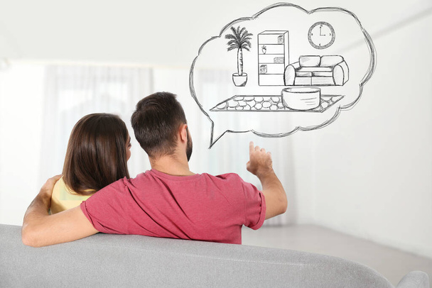 Moving to new house. Couple imagining living room arrangement. Illustrated interior design in speech bubble - 写真・画像