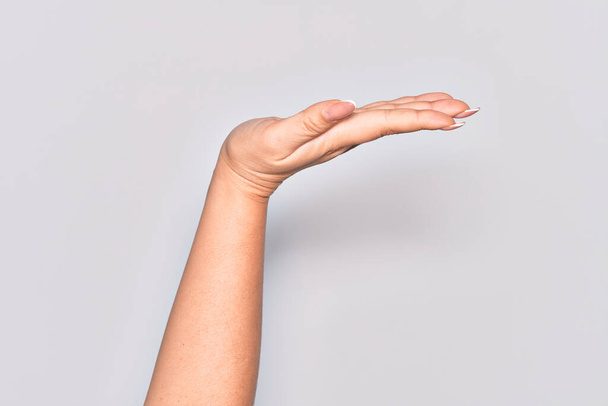Hand of caucasian young woman with flat palm presenting product, offer and giving gesture, blank copy space - Valokuva, kuva