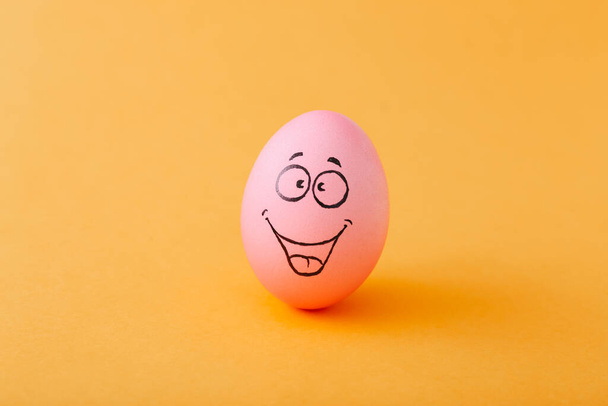 Huevo divertido con sensación de cara sobre fondo amarillo
 - Foto, imagen
