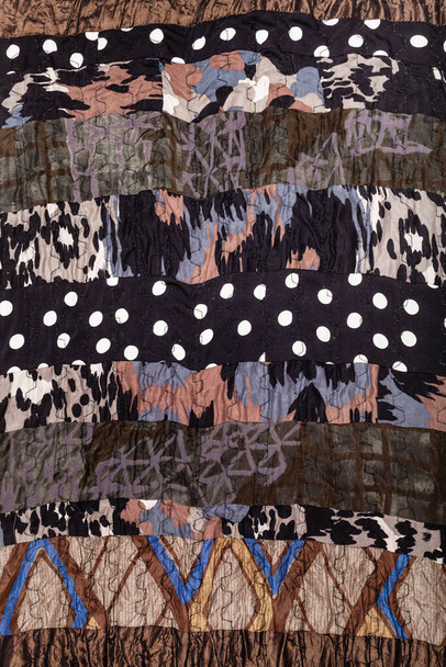 deel van handgemaakte bruine patchwork sjaal van diverse gestikte zijden stukken - Foto, afbeelding