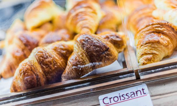 Fresh croissants put up for sale in a bakery store. - Fotoğraf, Görsel