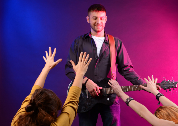 Guitarist singing on stage at a rock concert for his adoring fans - Φωτογραφία, εικόνα