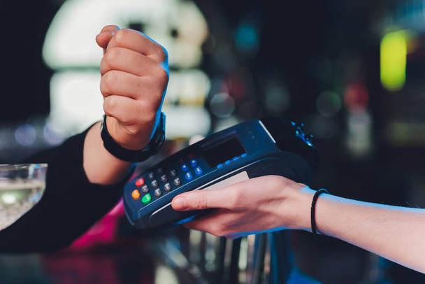 close up hand of young customer male paying with credit transaction by smart watch contactless terminal in modern shop, NFC technology. - Foto, Imagen