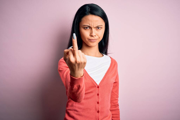 Young beautiful chinese woman wearing casual sweater over isolated pink background Showing middle finger, impolite and rude fuck off expression - Foto, Bild