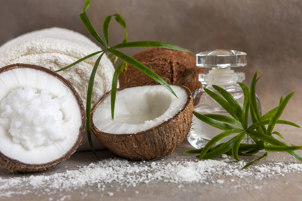 Close-up of Coconut, soft towels, coconut essence, coconut cream and tropical herbs. Spa concept, beauty and health salon, cosmetics store. - Fotoğraf, Görsel